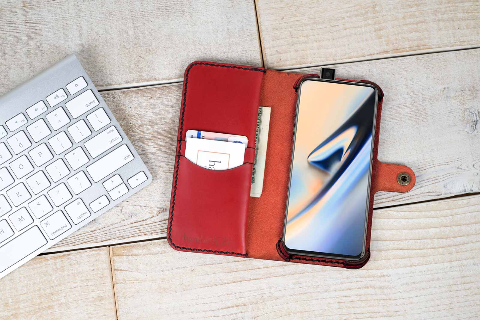 a red wallet case sitting next to a keyboard