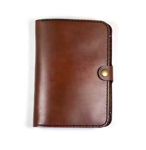 a brown leather wallet with a button on the front