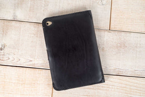 a black leather case sitting on top of a wooden floor
