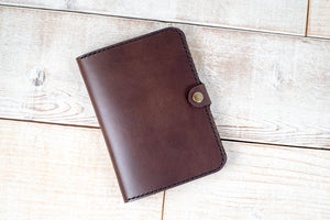 a brown leather wallet sitting on top of a wooden floor