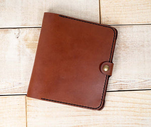 a brown leather journal sitting on top of a wooden floor
