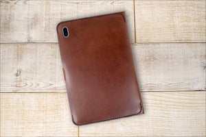 a brown leather case sitting on top of a wooden floor