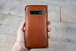 a person holding a brown case in their hand