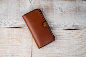 a brown wallet sitting on top of a wooden floor